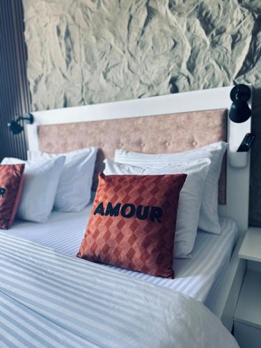 a bed with a pillow with the word amour on it at Apartman Viktorija in Žabljak