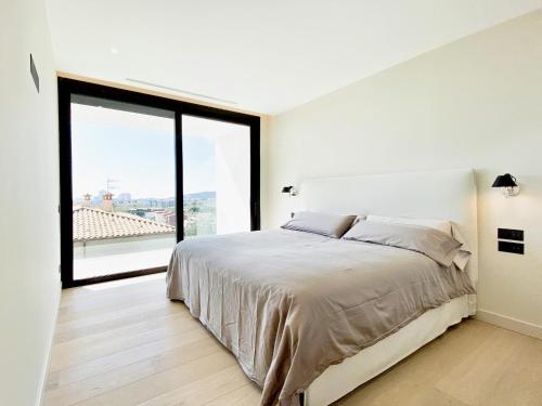 a bedroom with a large bed and a large window at Lux CostaBravaSi in Platja d'Aro