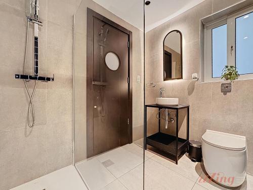 a bathroom with a shower and a toilet and a sink at South 32 Hotel by Zzzing in Birżebbuġa