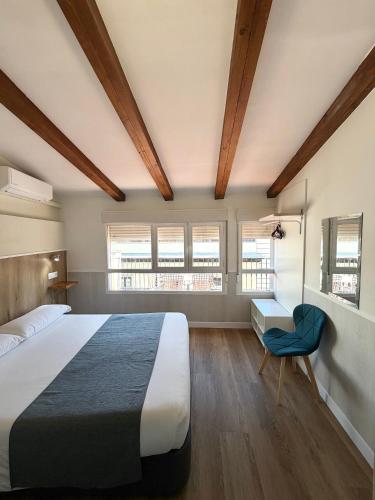 a bedroom with a large bed and a blue chair at Apartamentos Mayor Centro in Madrid