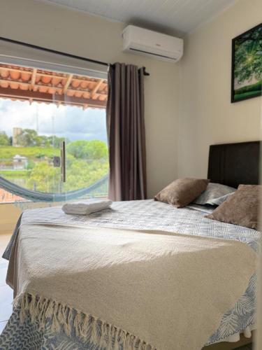 a bedroom with a large bed with a window at Pousada de Itajuípe em Itajuípe in Itajuípe