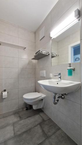 ein weißes Badezimmer mit Waschbecken und Toilette in der Unterkunft minimalissimo in Großenhain