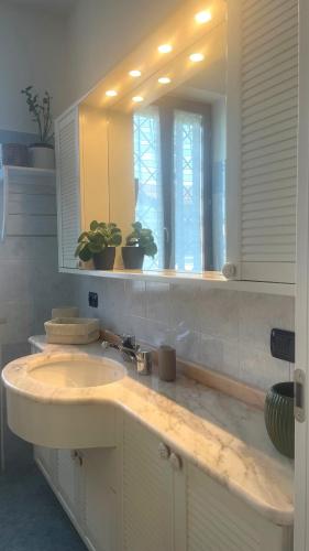 a bathroom with a sink and a mirror at Casa Chiaretto Piscina e Relax nel cuore di Moniga in Moniga
