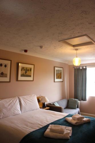 a hotel room with a bed and a couch at Yaxham Mill in East Dereham