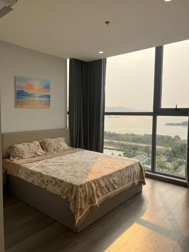 a bedroom with a bed and a large window at The Ruby Hạ Long in Ha Long