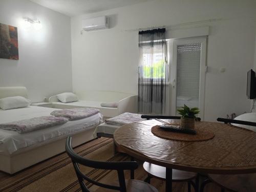 a living room with two beds and a table at Apartments Aldi in Mostar