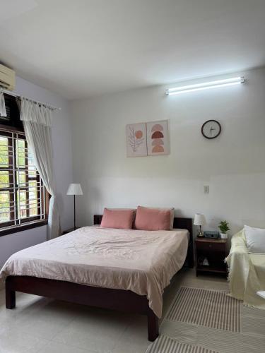 a bedroom with a large bed with pink pillows at Green home, Huế in Thôn Trường Giang