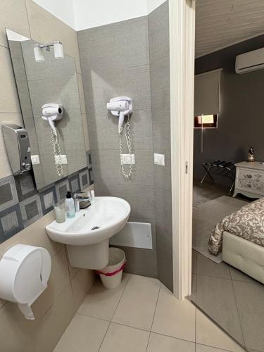 a bathroom with a sink and a toilet and a bed at La Regina Di Saba in Piazza Armerina