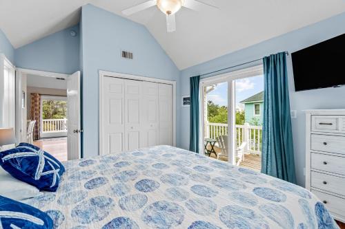 a bedroom with a large bed and a balcony at Rising Sun OBX in Corolla