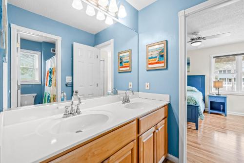 a bathroom with a sink and a mirror at Rising Sun OBX in Corolla