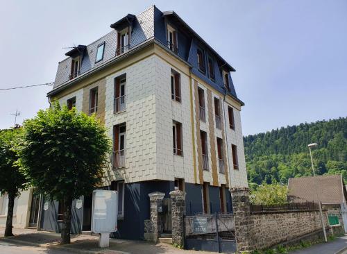 a large white building with a clock tower on top at La Maison des Familles 10 appartements in Le Mont-Dore