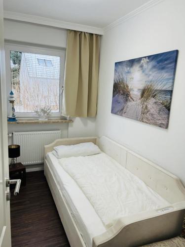 a bed in a room with a window at Haus Larum App. 3 in Scharbeutz