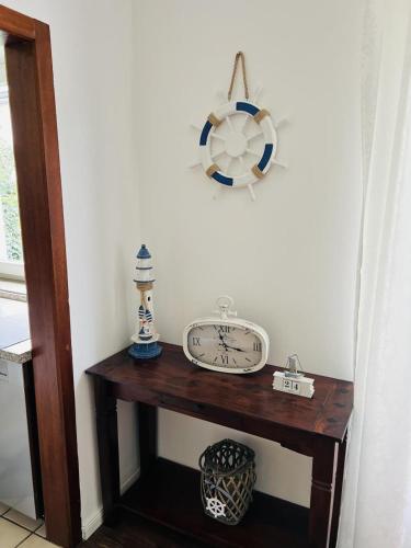 a wooden table with a clock on a wall at Haus Larum App. 3 in Scharbeutz