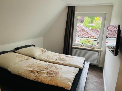 a bedroom with two beds and a window at Haus Larum App. 6 in Scharbeutz