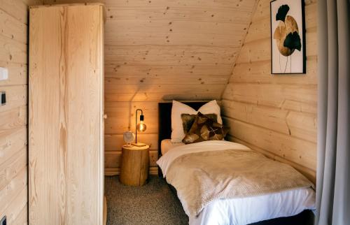 a bedroom with a bed in a log cabin at Ovis Homes I Gorąca balia - Widok na góry - 8 osób - Komfortowy domek in Zawoja