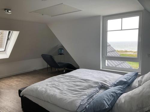 a bedroom with a bed and a large window at Meersicht Haffkrug in Haffkrug