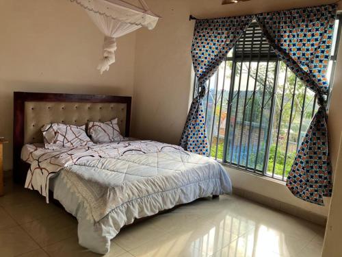 a bedroom with a bed and a large window at Bonnie's Homestay 