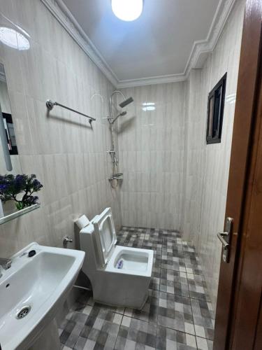 a bathroom with a toilet and a sink at Egel Appartement in Yaoundé