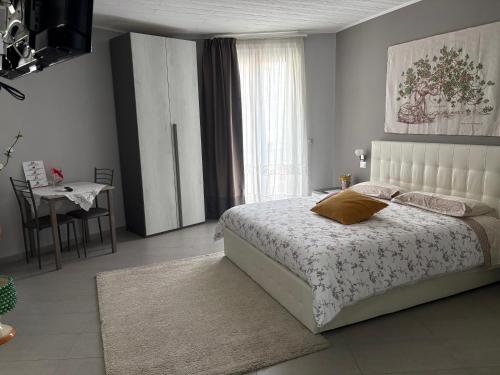 a bedroom with a bed and a table and a window at La Regina Di Saba in Piazza Armerina
