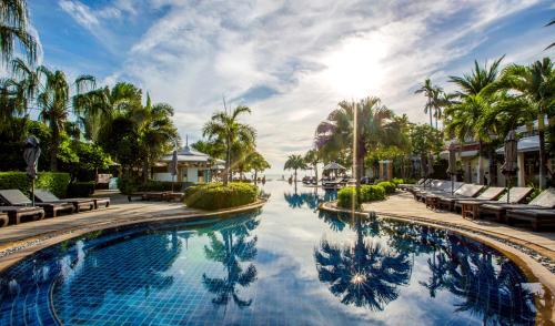 a swimming pool at a resort with palm trees at Wora Bura Hua Hin Resort & Spa in Hua Hin