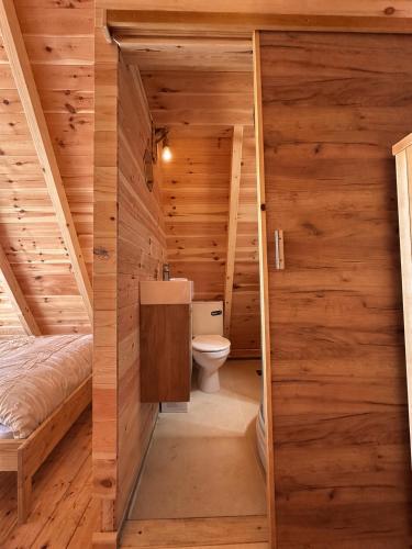 a bathroom in a log cabin with a toilet at Gorska Dolina in Ivanova Korita