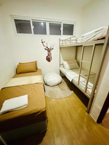 two bunk beds in a room with wooden floors at Bayanihan Flats 2 in Pajak