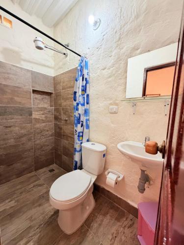 a bathroom with a toilet and a sink at Finca Hostal Ágora in Jardin