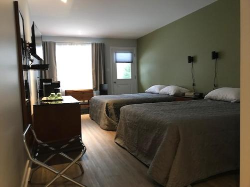 a hotel room with two beds and a window at Motel Domaine Expédition in Labelle