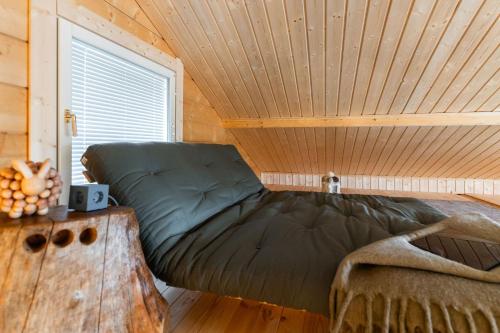 a bed in a room with a wooden ceiling at Tupa Lodge by The Guide Father in Rovaniemi