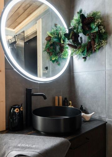 a bathroom with a black sink and a mirror at Tupa Lodge by The Guide Father in Rovaniemi