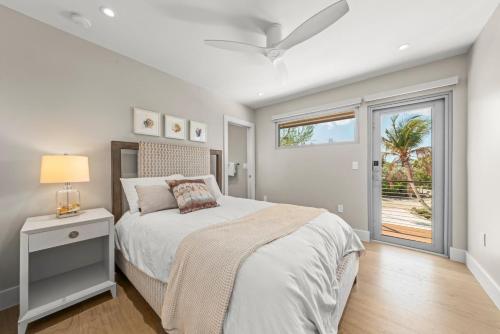 a white bedroom with a bed and a window at Bentley Beach House in Sanibel
