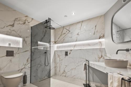 a bathroom with a shower and a toilet and a sink at Riviera Beach Hotel in Mandelieu-La Napoule