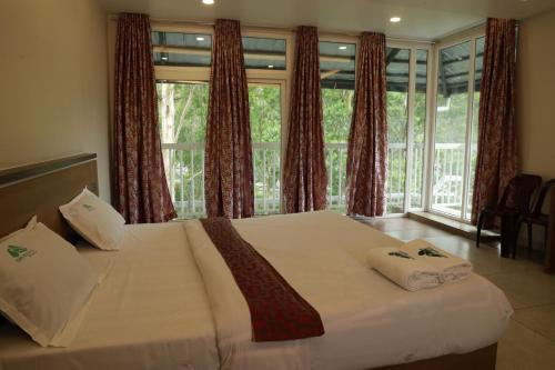 a bedroom with a bed with two towels on it at Eden Holidays EV in Munnar
