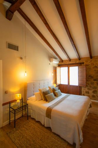a bedroom with a large white bed and a window at Hospedium Hotel Rural Ruta Imperial H-CC-00660 in Jarandilla de la Vera