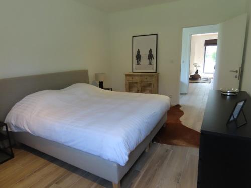 a bedroom with a large white bed and a desk at Appartement 2 chambres Rochefort in Rochefort