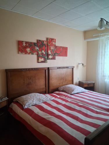 a bed in a bedroom with two paintings on the wall at Maison de Jeanne in Eschau