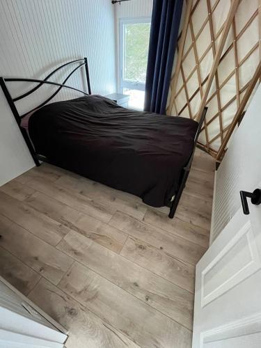 a bed in a small room with a wooden floor at Havre du Lac Montagnais in Saint-Fulgence