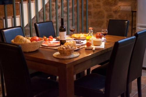 a wooden table with food and wine and wine glasses at Casa Tomás in Calaceite