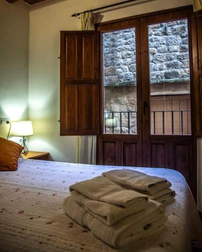a bedroom with a bed with a pile of towels on it at Casa Tomás in Calaceite
