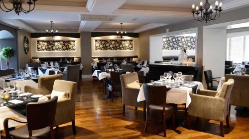 a restaurant with tables and chairs in a room at Cill Aodain Court Hotel in Kiltimagh