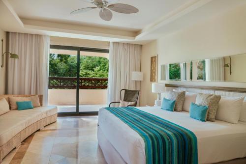 a bedroom with a large bed and a couch at Catalonia Royal Tulum Beach & Spa Resort Adults Only - All Inclusive in Xpu Ha