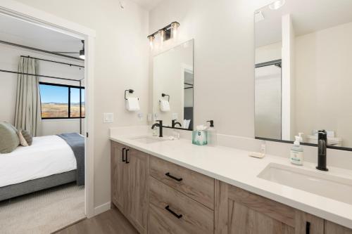 a bathroom with a double sink and a bed at 103 Granby Meadow Dr in Granby