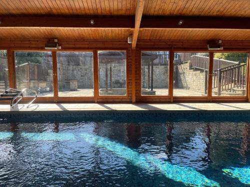a swimming pool with glass windows and a swimming pool at Habberjam Farm - Swimming pool, Hot Tub, Sauna, Games Room in Sheffield