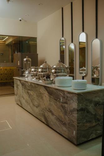 a kitchen with a counter with dishes on it at Hotel Bariz Perinthalmanna in Perintalmanna
