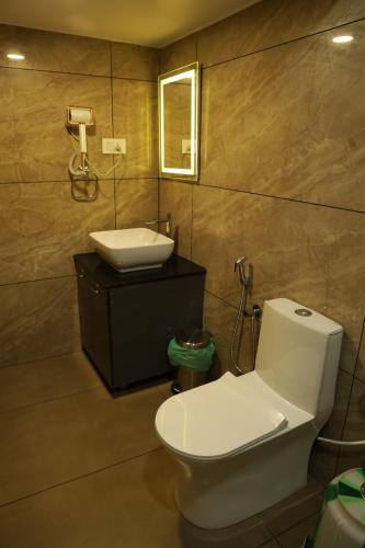 a bathroom with a white toilet and a sink at Eden Holidays EV in Munnar