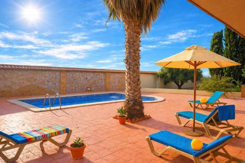 a patio with chairs and an umbrella and a pool at La Casona del Olivo - Pool, Patio, BBQ & Pet-Friendly in Torre-Pacheco