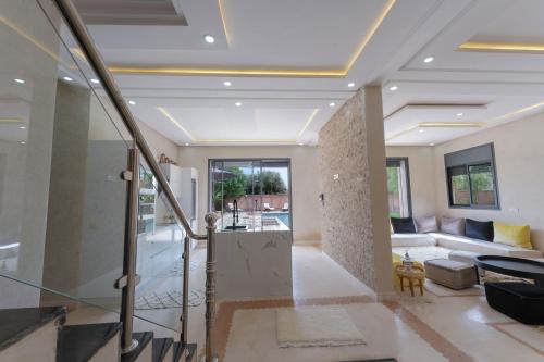 a living room with a staircase and a couch at Dar El Gharrabia villa entièrement privatisée in Amezrou