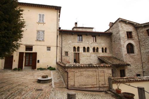 ein altes Steingebäude mit einem Tor davor in der Unterkunft Vescovado 7 in Gubbio