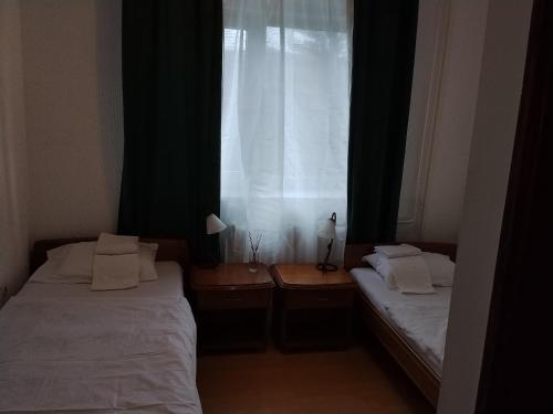 two beds in a small room with a window at Motel Buče in Berane