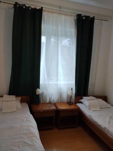 a bedroom with two beds and a window with curtains at Motel Buče in Berane
